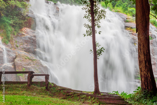 Natural blurred background of waterfalls, fast-flowing currents and water droplets from the wind blowing among the rocks and surrounded by big trees, spontaneous beauty photo