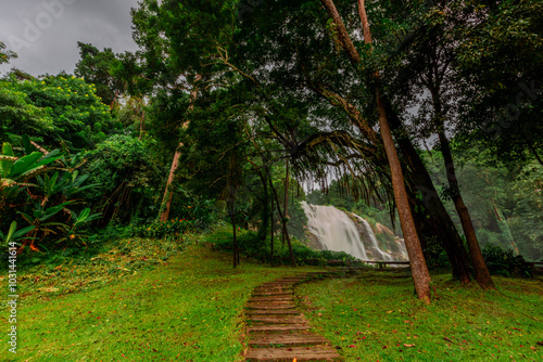 Natural blurred background of waterfalls, fast-flowing currents and water droplets from the wind blowing among the rocks and surrounded by big trees, spontaneous beauty