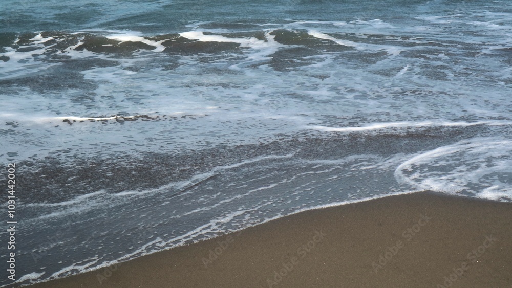 Waves crashing against the shore with a clear blue sky in the background at Parangtritis Beach, Yogyakarta. Waves crashing against the shore with a clear blue sky in the background at Parangtritis Beach, Yogyakarta.