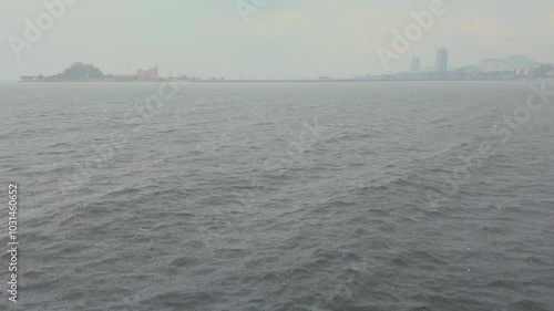 Slow motion shot of Overcast Day Over Calm Waters with City Skyline and Distant Hills in the Background with the rainy day