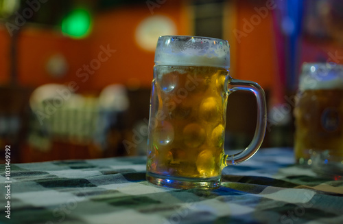  A glass of beer on wooden table. Nice soft background.