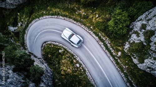 Wallpaper Mural An aerial view of a silver classic car driving on a winding road through a mountainous landscape. Torontodigital.ca