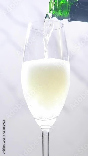 よく冷えたシャンパン（スパークリングワイン）をシャンパン用のフルートグラスに注ぐビデオ素材（縦型）
