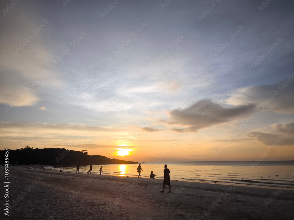Beach during sunset, evening dream, dark sky showing people relaxing Beach during sunset, evening dream, dark sky showing people relaxing