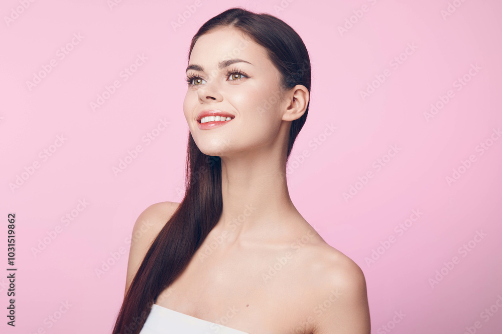 Young woman with long brown hair posing on pink background with white towel on head and pink lipstick on lips Young woman with long brown hair posing on pink background with white towel on head and pink lipstick on lips