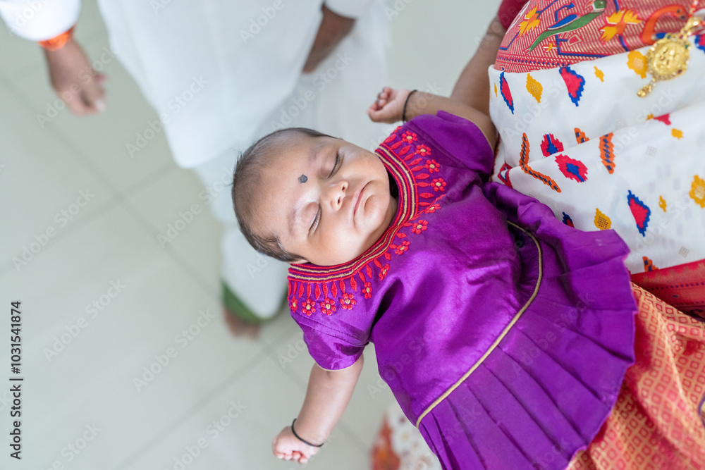 Obraz premium ndian family spending time together, wearing traditional and casual outfits with a baby, a young girl, and grandparents in a high-rise apartment in Kuala Lumpur, Malaysia.