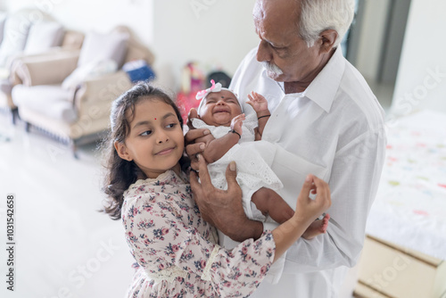 Photography ndian family spending time together, wearing traditional and casual outfits with a baby, a young girl, and grandparents in a high-rise apartment in Kuala Lumpur, Malaysia
