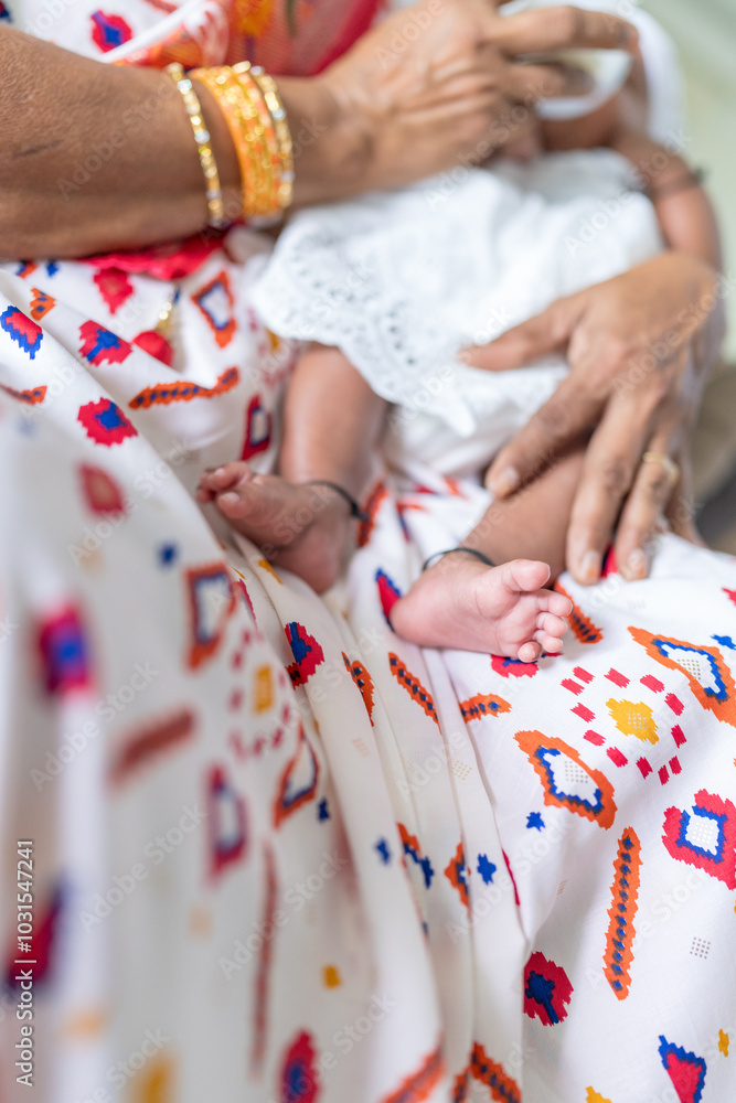 Obraz premium ndian family spending time together, wearing traditional and casual outfits with a baby, a young girl, and grandparents in a high-rise apartment in Kuala Lumpur, Malaysia.