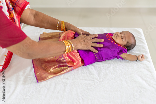 ndian family spending time together, wearing traditional and casual outfits with a baby, a young girl, and grandparents in a high-rise apartment in Kuala Lumpur, Malaysia. photo