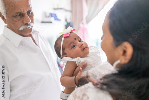 Photography ndian family spending time together, wearing traditional and casual outfits with a baby, a young girl, and grandparents in a high-rise apartment in Kuala Lumpur, Malaysia