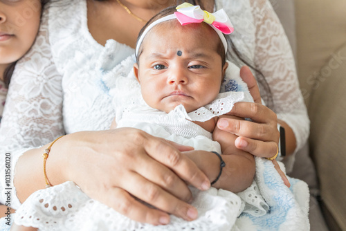 ndian family spending time together, wearing traditional and casual outfits with a baby, a young girl, and grandparents in a high-rise apartment in Kuala Lumpur, Malaysia. photo