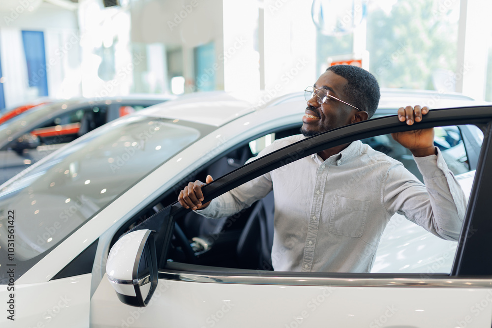 Handsome African American man customer client in suit get out car, touch door. Concept sales automobile in showroom vehicle store Handsome African American man customer client in suit get out car, touch door. Concept sales automobile in showroom vehicle store