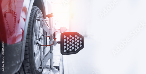 Closeup car wheel alignment on stand with sensors check in service station. Vehicle inside garage workshop for auto camber fixing work. photo