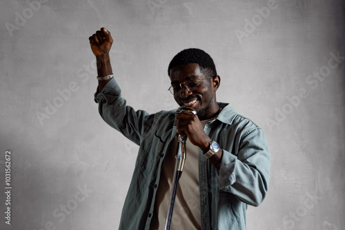 Photography Handsome young African American singer standing with retro microphone singing so