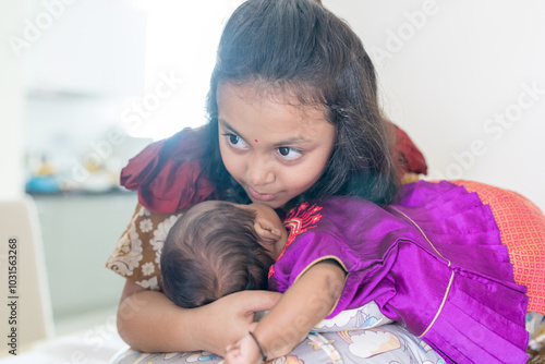 ndian family spending time together, wearing traditional and casual outfits with a baby, a young girl, and grandparents in a high-rise apartment in Kuala Lumpur, Malaysia. photo