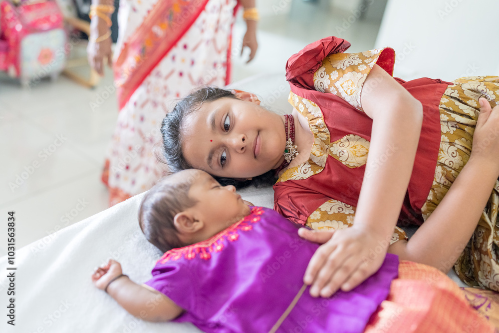 Fototapeta premium ndian family spending time together, wearing traditional and casual outfits with a baby, a young girl, and grandparents in a high-rise apartment in Kuala Lumpur, Malaysia.
