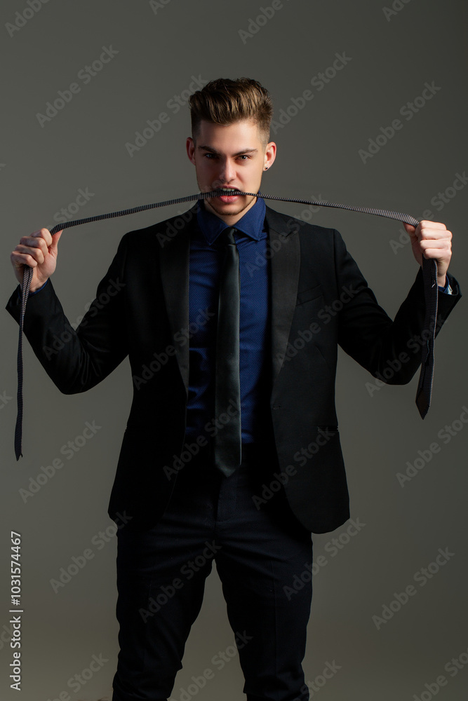 Formal wear of men. The Necktie for tuxedo or official suit. Ties and bows. Businessman costume. Male model with necktie. Young man in classy suit adjusting tie. Model fashion look. Guy tie a tie. Formal wear of men. The Necktie for tuxedo or official suit. Ties and bows. Businessman costume. Male model with necktie. Young man in classy suit adjusting tie. Model fashion look. Guy tie a tie.