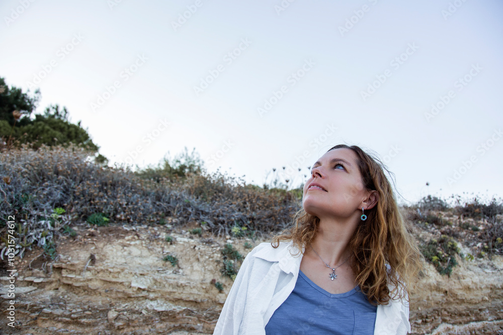 Beautiful young woman looking to the sky and smiling Beautiful young woman looking to the sky and smiling