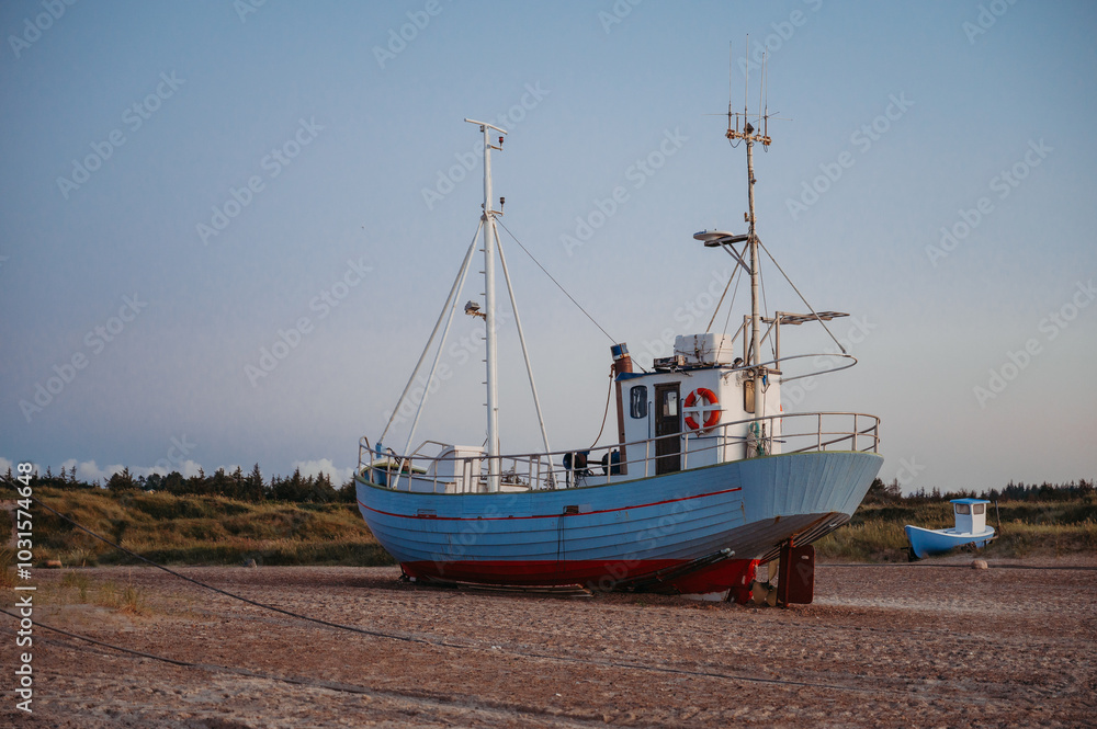 Fishing boats on Slettestrand Beach, Denmark, at sunset by the sea Fishing boats on Slettestrand Beach, Denmark, at sunset by the sea