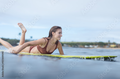 Woman paddling back out to surf photo