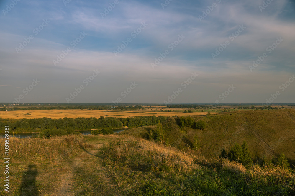 A large, open field with a river running through it A large, open field with a river running through it