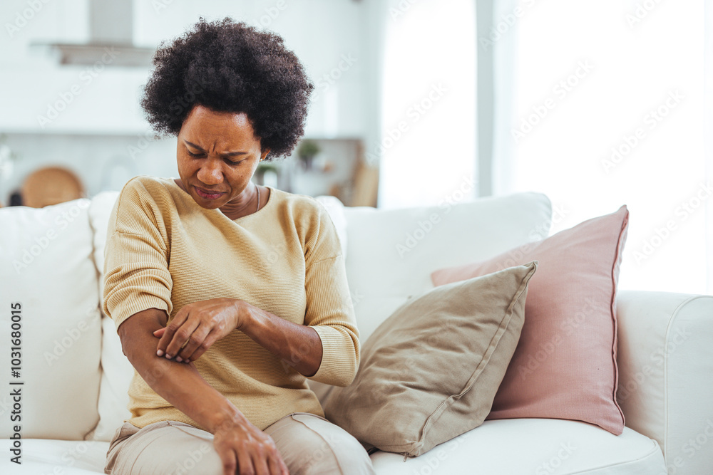 Woman Experiencing Skin Irritation While Sitting on Couch Woman Experiencing Skin Irritation While Sitting on Couch