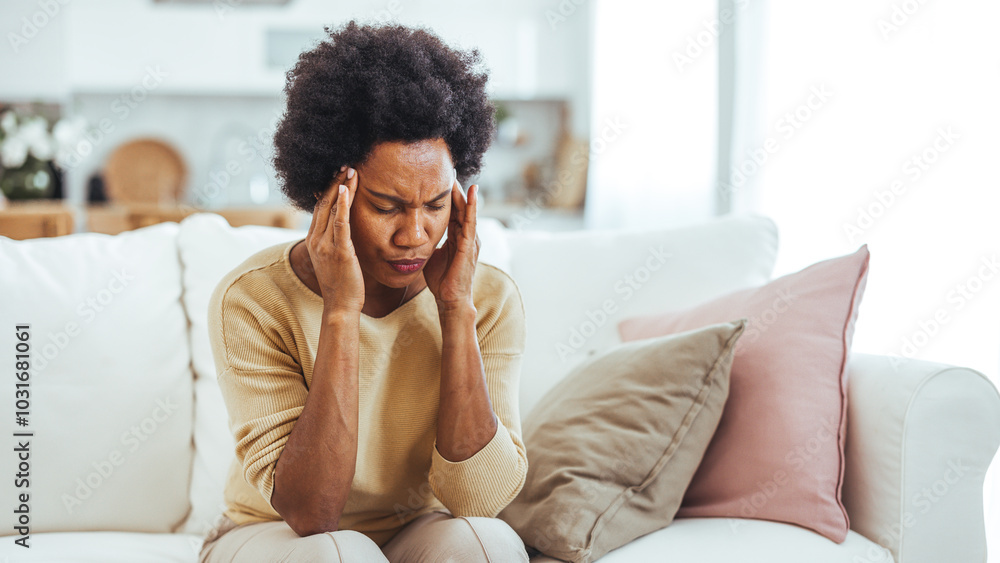 Stressed Woman Sitting on Sofa Holding Her Head in Hands Stressed Woman Sitting on Sofa Holding Her Head in Hands