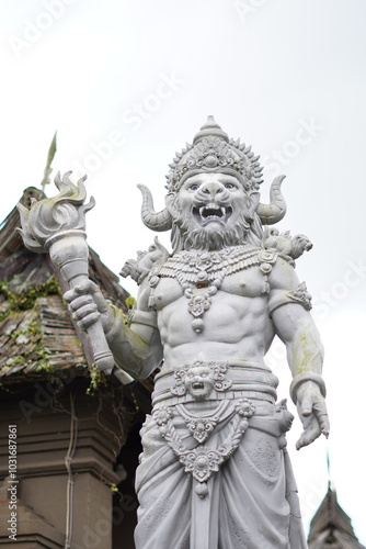 A typical Balinese stone carving statue holding a torch