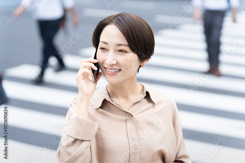 ビル街で通話をする女性