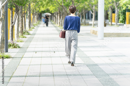 並木道を歩いている女性 