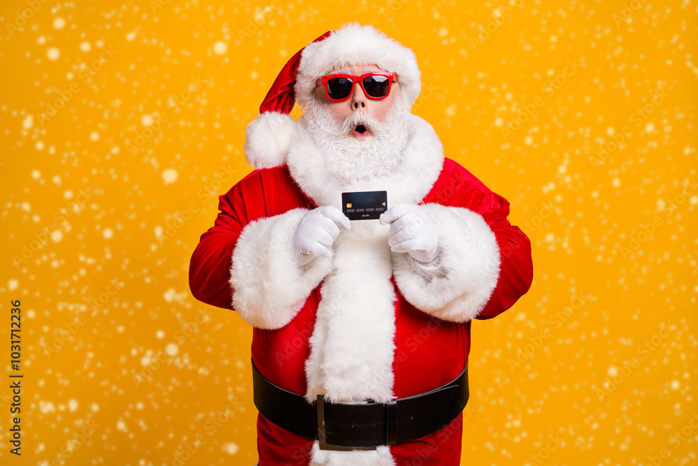 Portrait of his he nice attractive amazed stunned wondered Santa holding in hand bank card budget safe shopping investment isolated bright vivid shine vibrant yellow color background Portrait of his he nice attractive amazed stunned wondered Santa holding in hand bank card budget safe shopping investment isolated bright vivid shine vibrant yellow color background