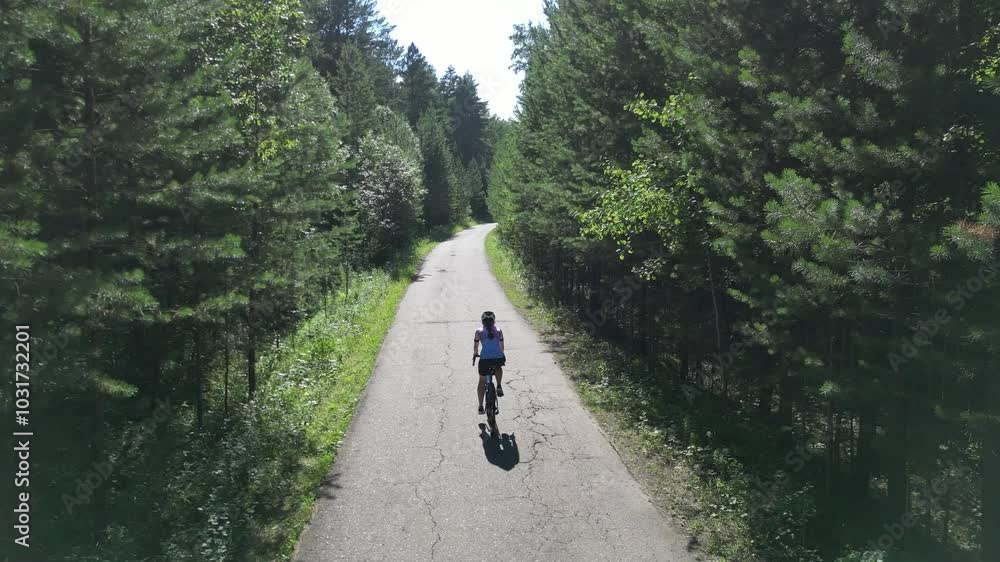 Professional road cyclist on fast and light carbon bicycle descends mountain road in siberia Professional road cyclist on fast and light carbon bicycle descends mountain road in siberia