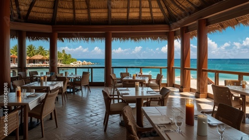 An open-air restaurant with thatched roof and wooden pillars overlooking a tropical ocean with palm trees and blue sky.