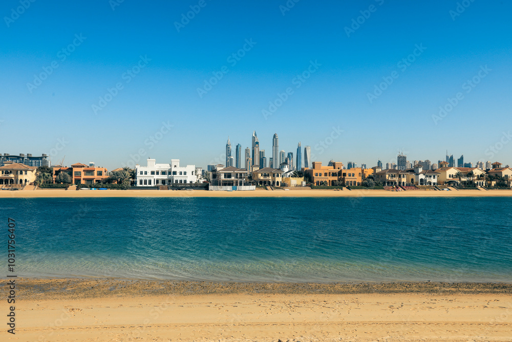 Naklejka premium Scenic view of Dubai beachfront highlighting modern architecture and calm waters on a bright sunny day