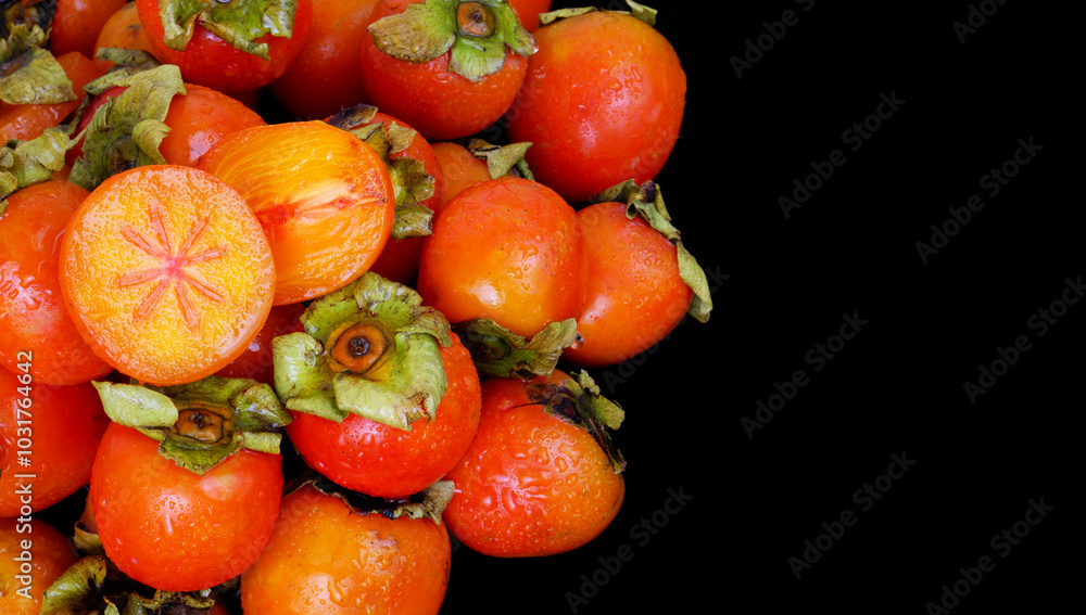 Wet persimmon fruits isolated on black background. Copy space for text. Wet persimmon fruits isolated on black background. Copy space for text.