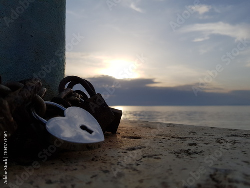 Foto tramonto romantico sul mare con lucchetti a cuore