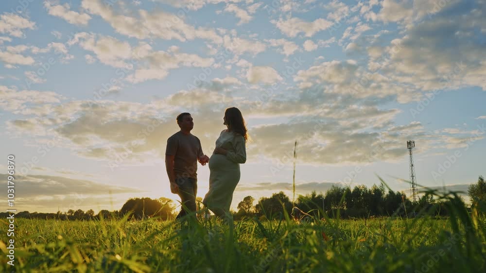Couple enjoys sunset stroll in a scenic field on a warm summer evening Couple enjoys sunset stroll in a scenic field on a warm summer evening