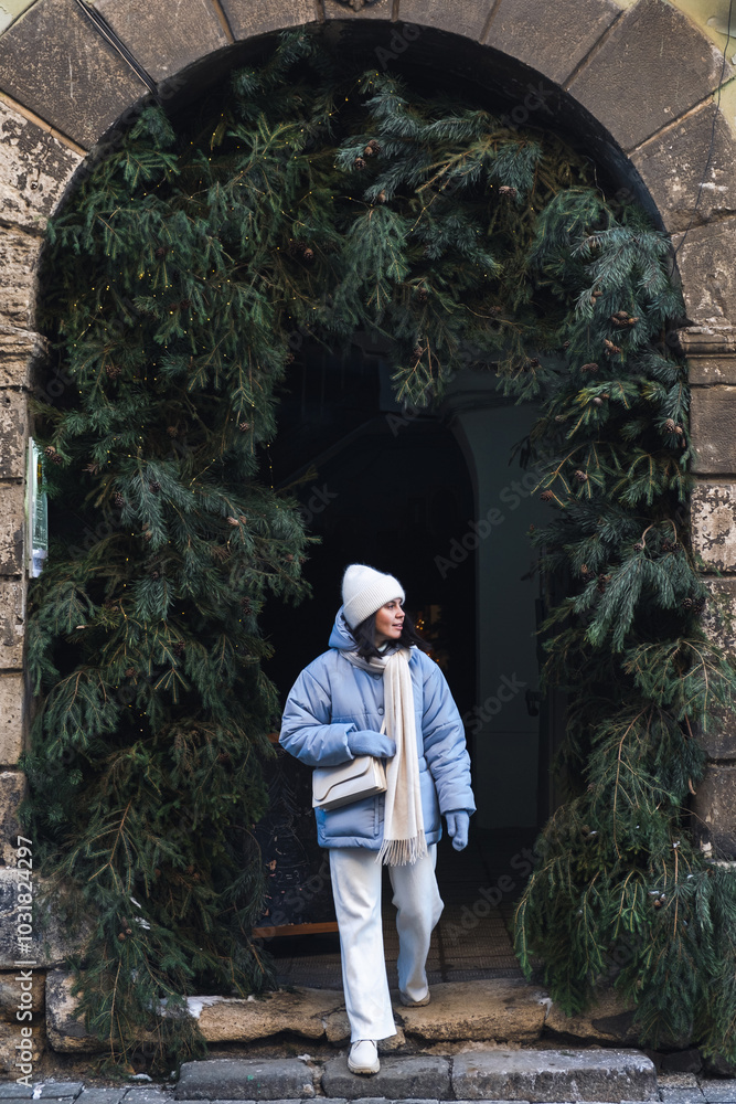 woman walking by city street decorated for christmas
