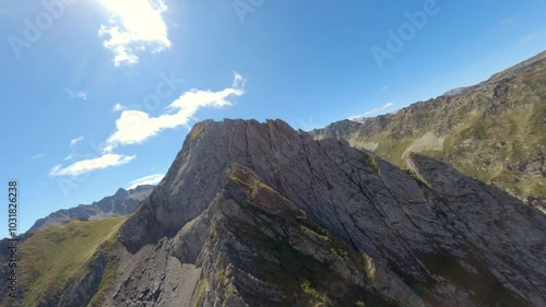 Aerial FPV drone view descending fast from a mountain peak in a beautiful sunny summer day in the Pyrene mountains, France photo