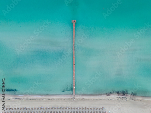 Aerial drone view of wooden pier and turquoise waters at Playa de Muro, Alcudia, Mallorca