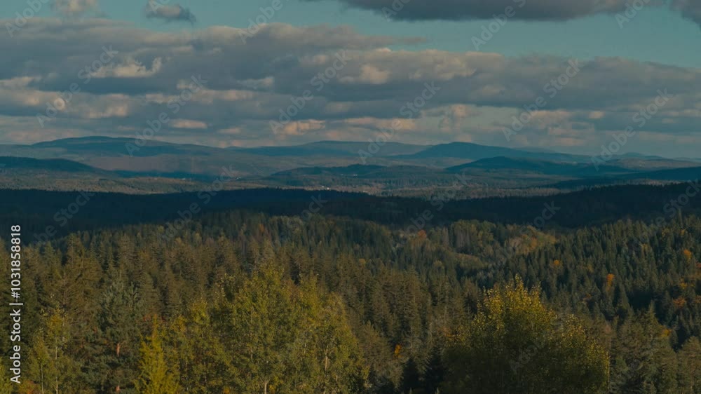 Timelapse of a vast forest landscape with rolling hills and mountains under a dynamic sky with passing clouds. Concept of natural beauty, time passage, and environmental serenity Timelapse of a vast forest landscape with rolling hills and mountains under a dynamic sky with passing clouds. Concept of natural beauty, time passage, and environmental serenity