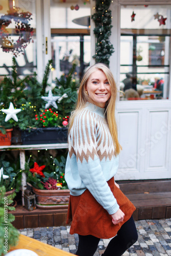 Portrait of beautiful attractive smiling slavic young girl enjoying holiday Christmas market, Winter, snowy day, festive city new year atmosphere