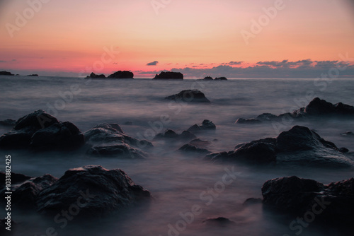 Sea and rocks at sunset . Long exposure