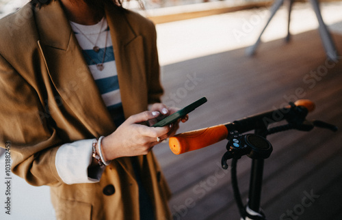 Woman using phone and app while using electric scooter