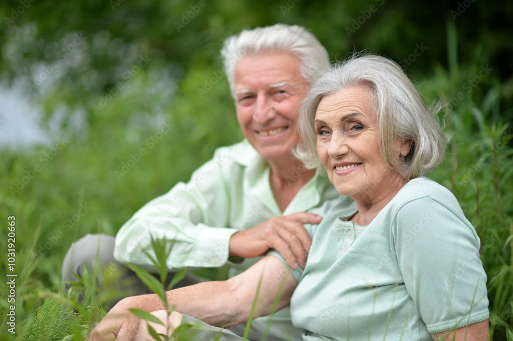 Portrait of senior couple sitting on the grass in the park Portrait of senior couple sitting on the grass in the park