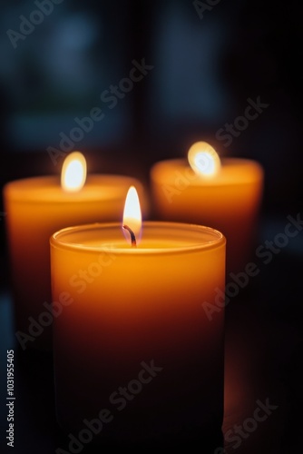 Many lit candles glow softly at dusk, creating a serene atmosphere in a peace...