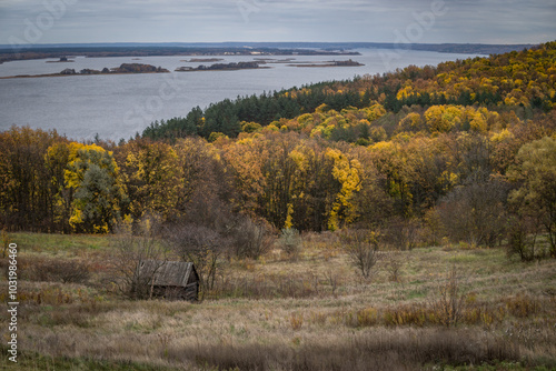 The hill overlooks the river, surrounded by yellow trees that seem to dip autumn into the water.