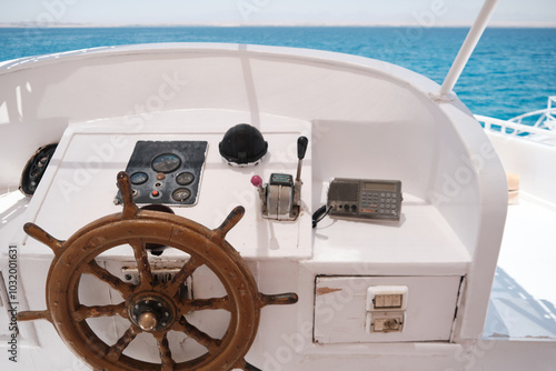 Steering wheel of a boat. Wooden helm of yacht in the sea