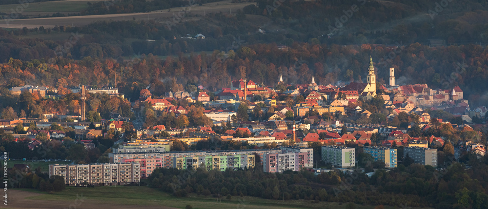 Bystrzyca Klodzka, a small town in a mountain valley, a view of the city's buildings from the hiking trail in the Bystrzyckie Mountains. Landscape in the evening.