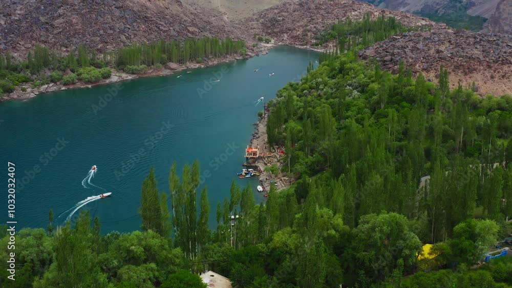 Drone shot over Skardu city with green mountains and forests with a lake view Drone shot over Skardu city with green mountains and forests with a lake view